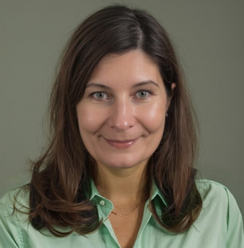 a woman in a green shirt smiling at the camera
